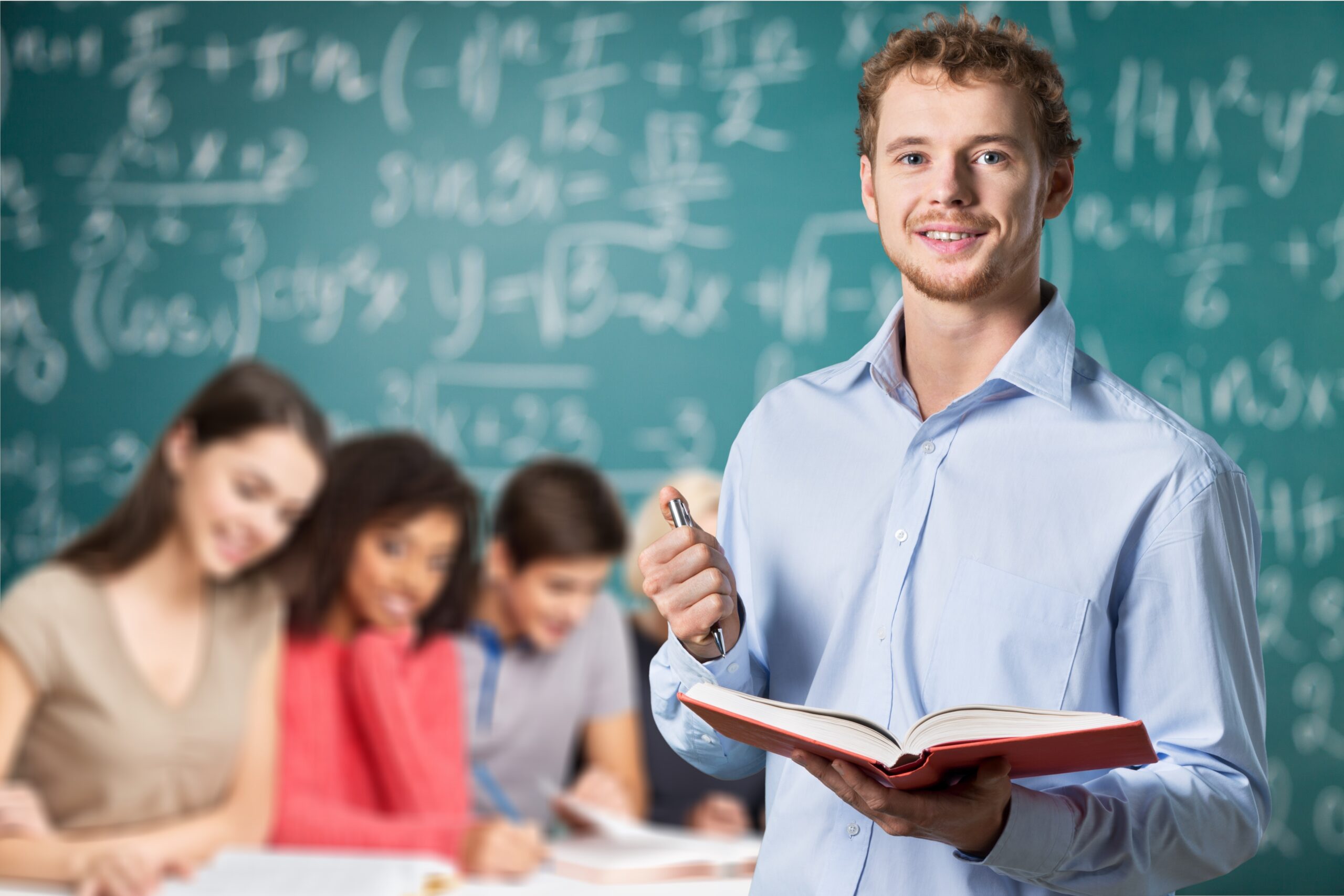 Young male teacher   standing with book